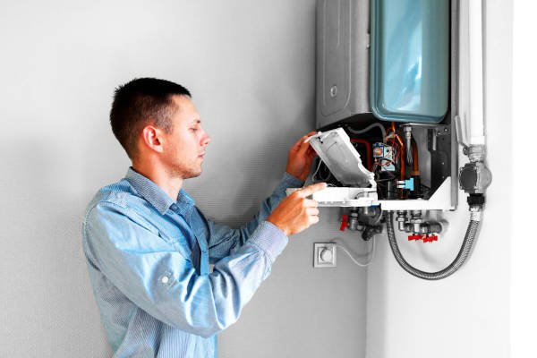 A technician inspecting and installing a water heater.